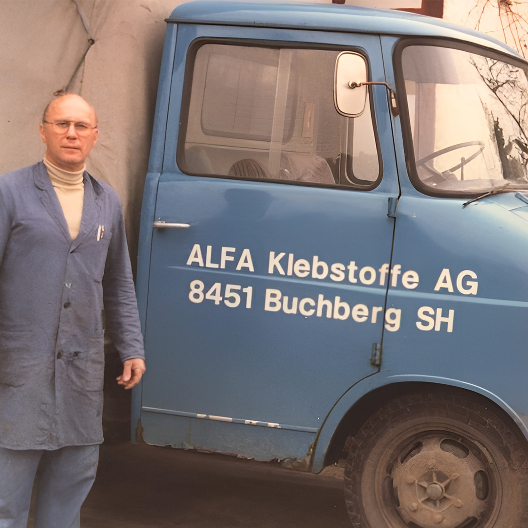 自1972年起成为可持续发展地先驱 4 Historisches Foto eines ALFA Klebstoffe-Fahrzeugs mit einem Mitarbeiter davor, aufgenommen vor dem Unternehmenssitz in Buchberg.