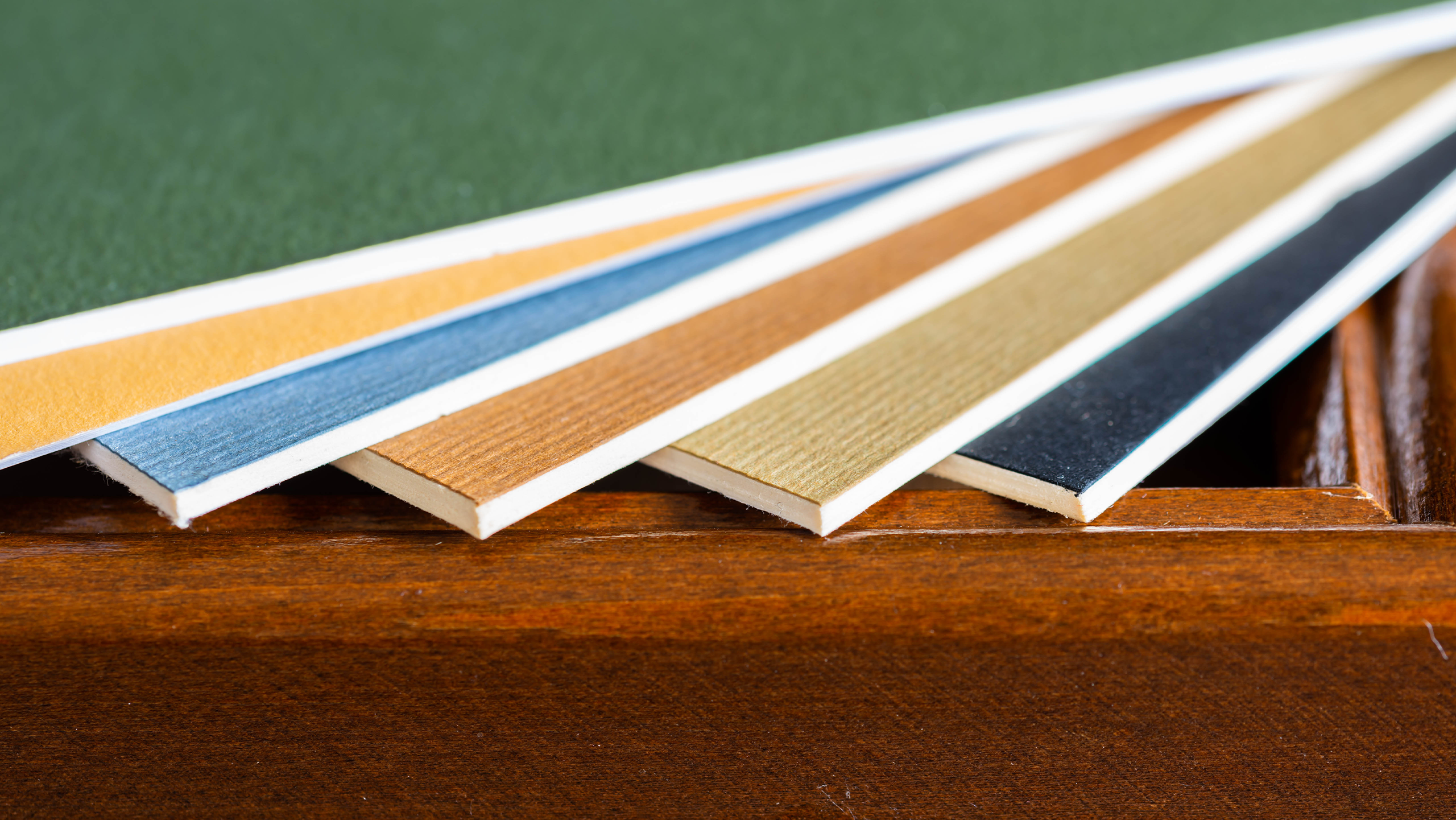 ALFAST® 15 Verschiedene Papiermuster in verschiedenen Farben, die auf einer Holzoberfläche gestapelt sind.